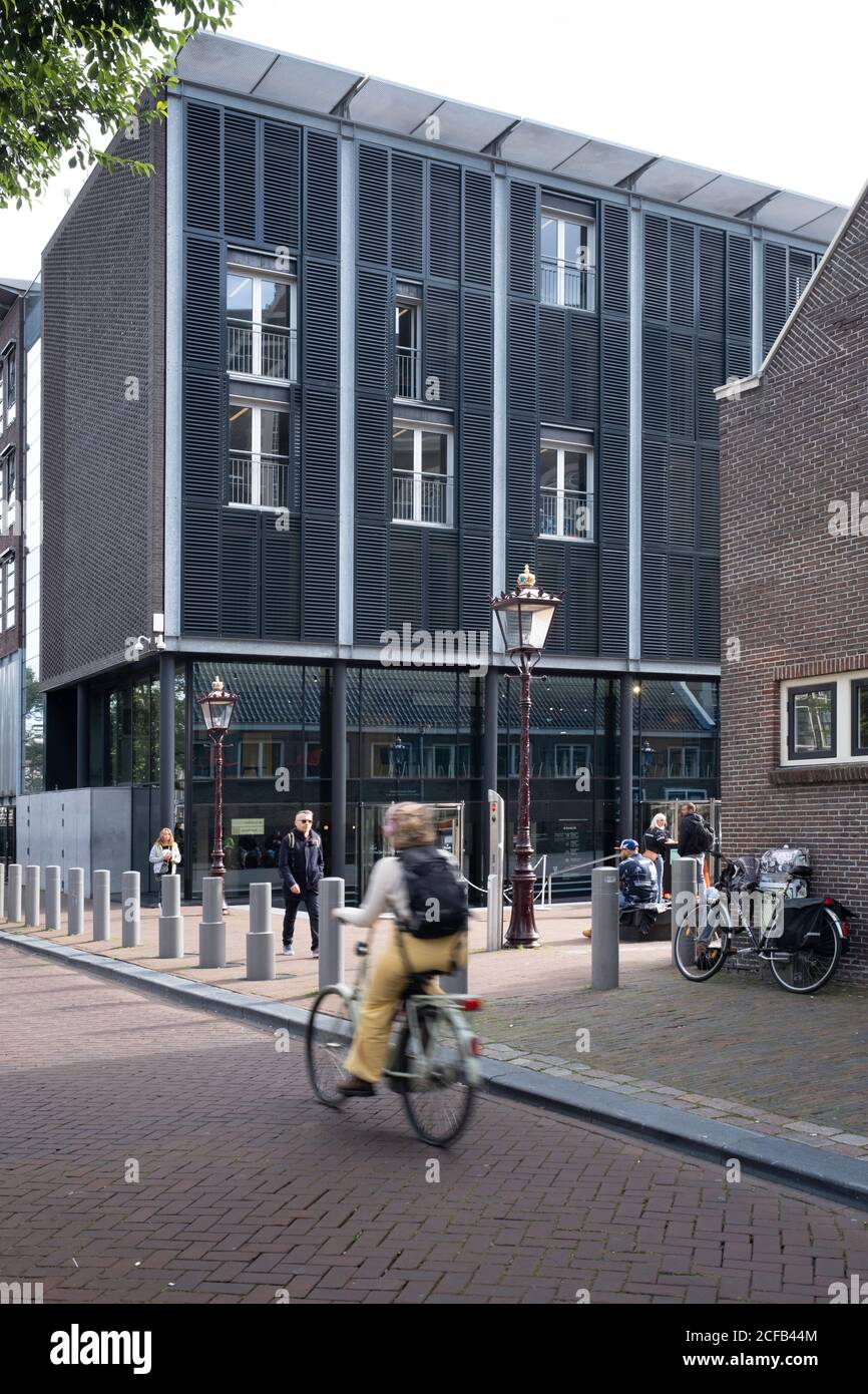 Il ciclista corre sul Prinsengracht di fronte alla Anna Frank House Museum di Amsterdam Foto Stock