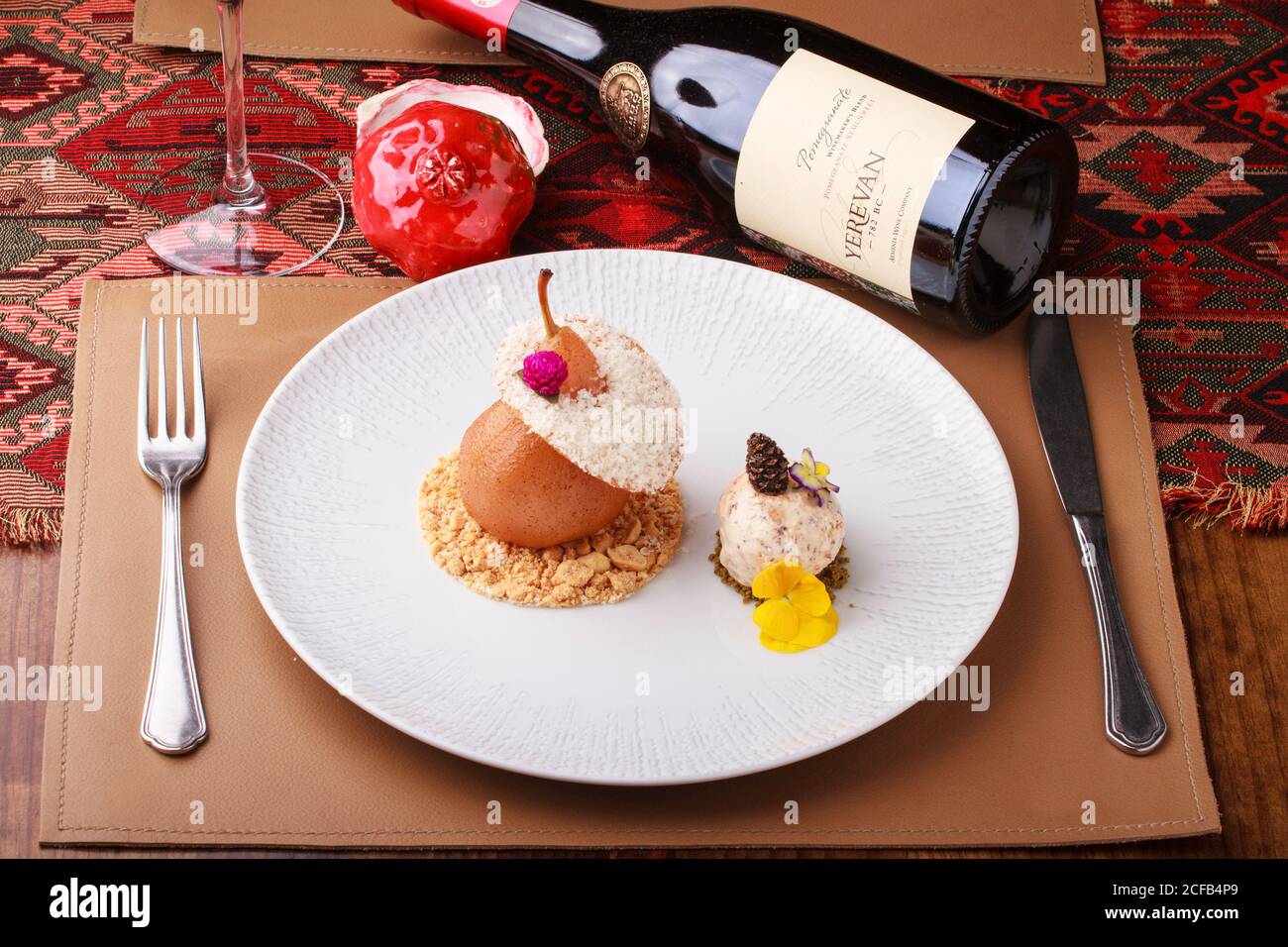 Par dessert in camicia con pralina e gelato alla noci. Servito con una bottiglia di vino melograno. Foto Stock