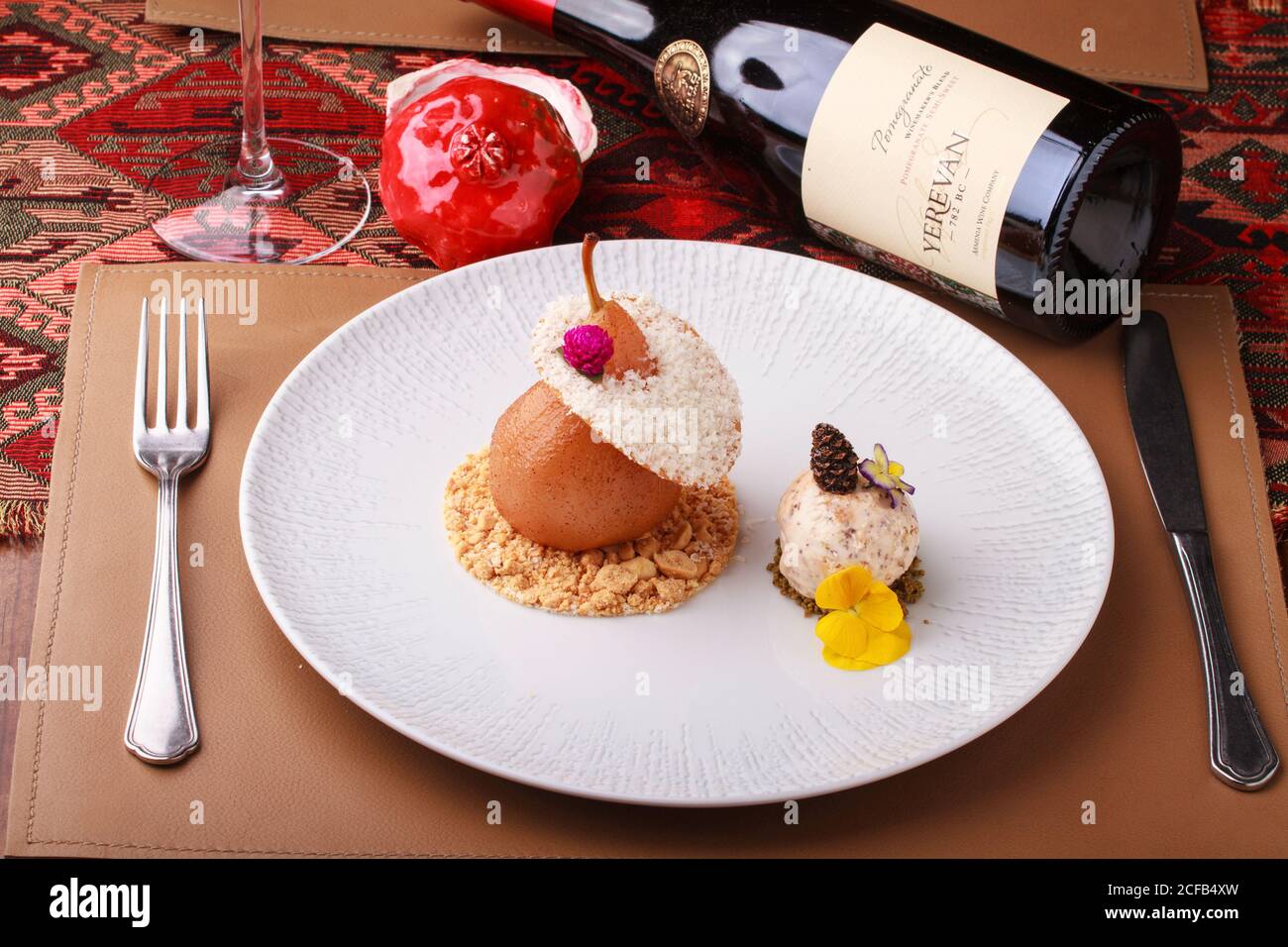 Par dessert in camicia con pralina e gelato alla noci. Servito con una bottiglia di vino melograno. Foto Stock