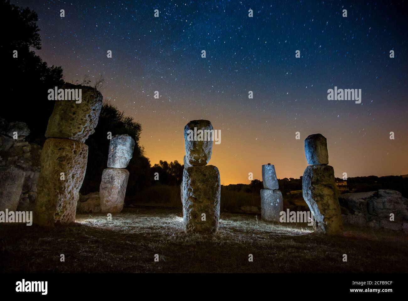 Rock monumenti evidenziati da luci e cielo stupefacente con stelle di notte Foto Stock