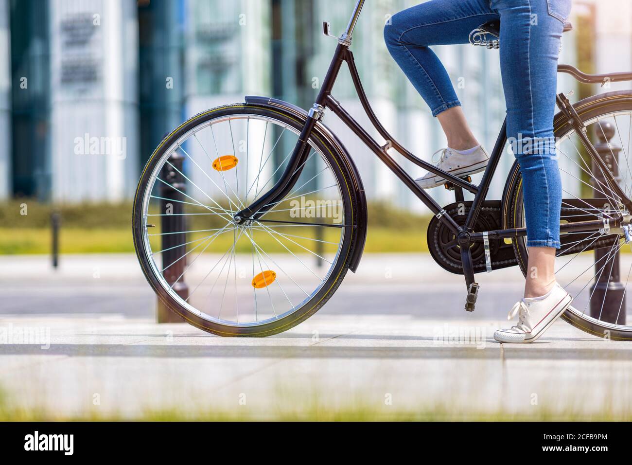 Giovane donna con la bicicletta in città Foto Stock