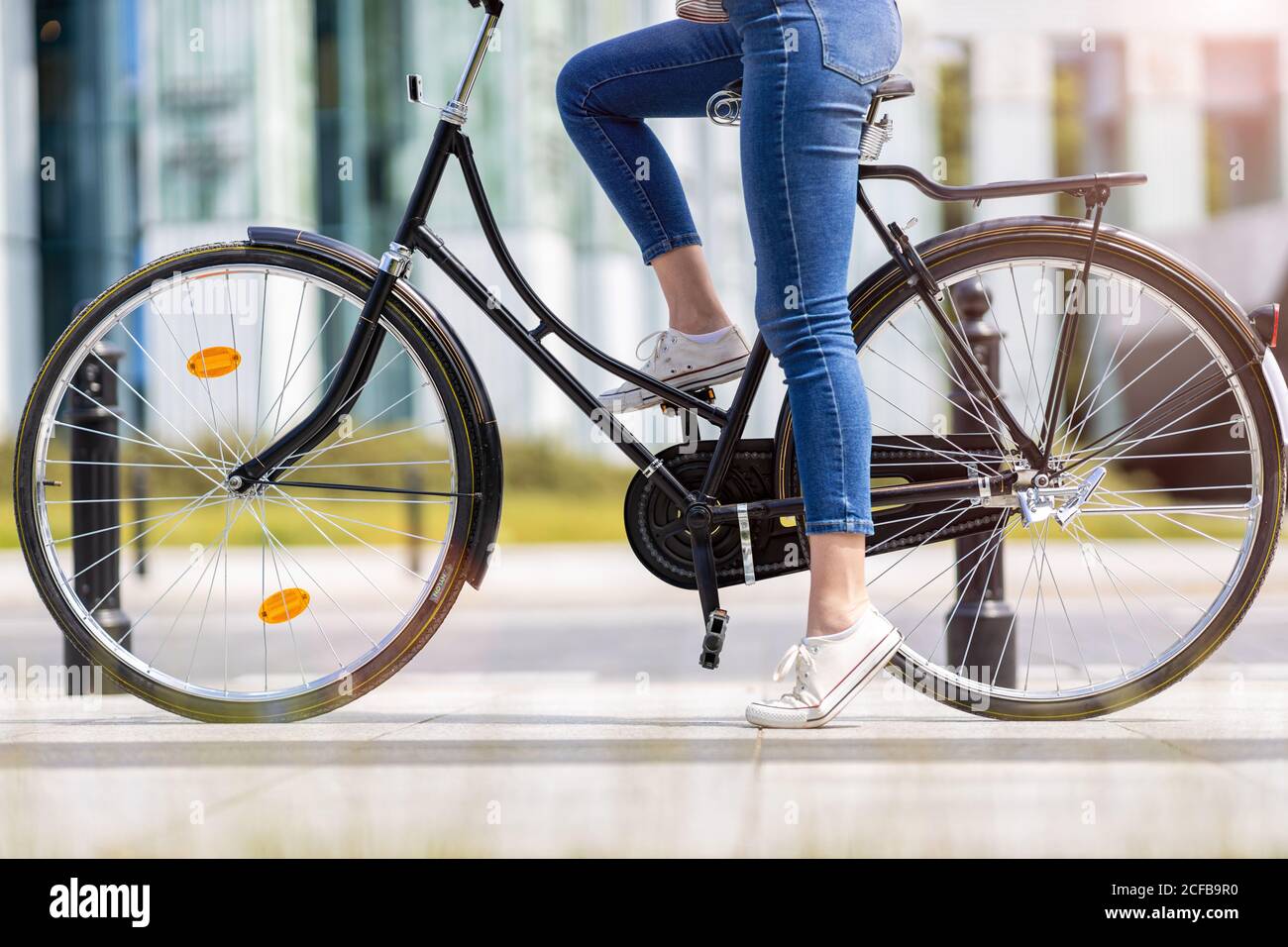 Giovane donna con la bicicletta in città Foto Stock