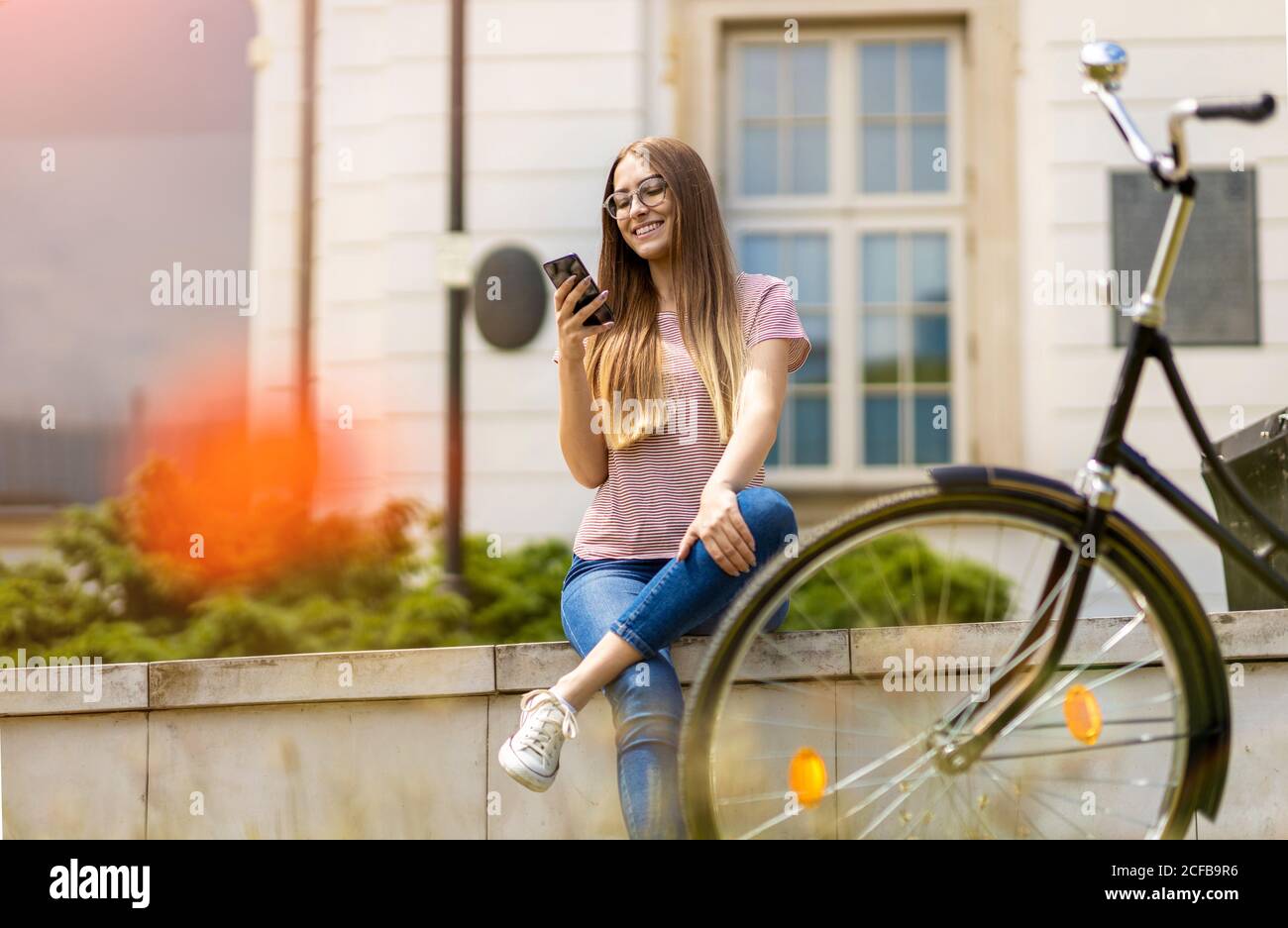 Giovane donna con la bicicletta in città Foto Stock