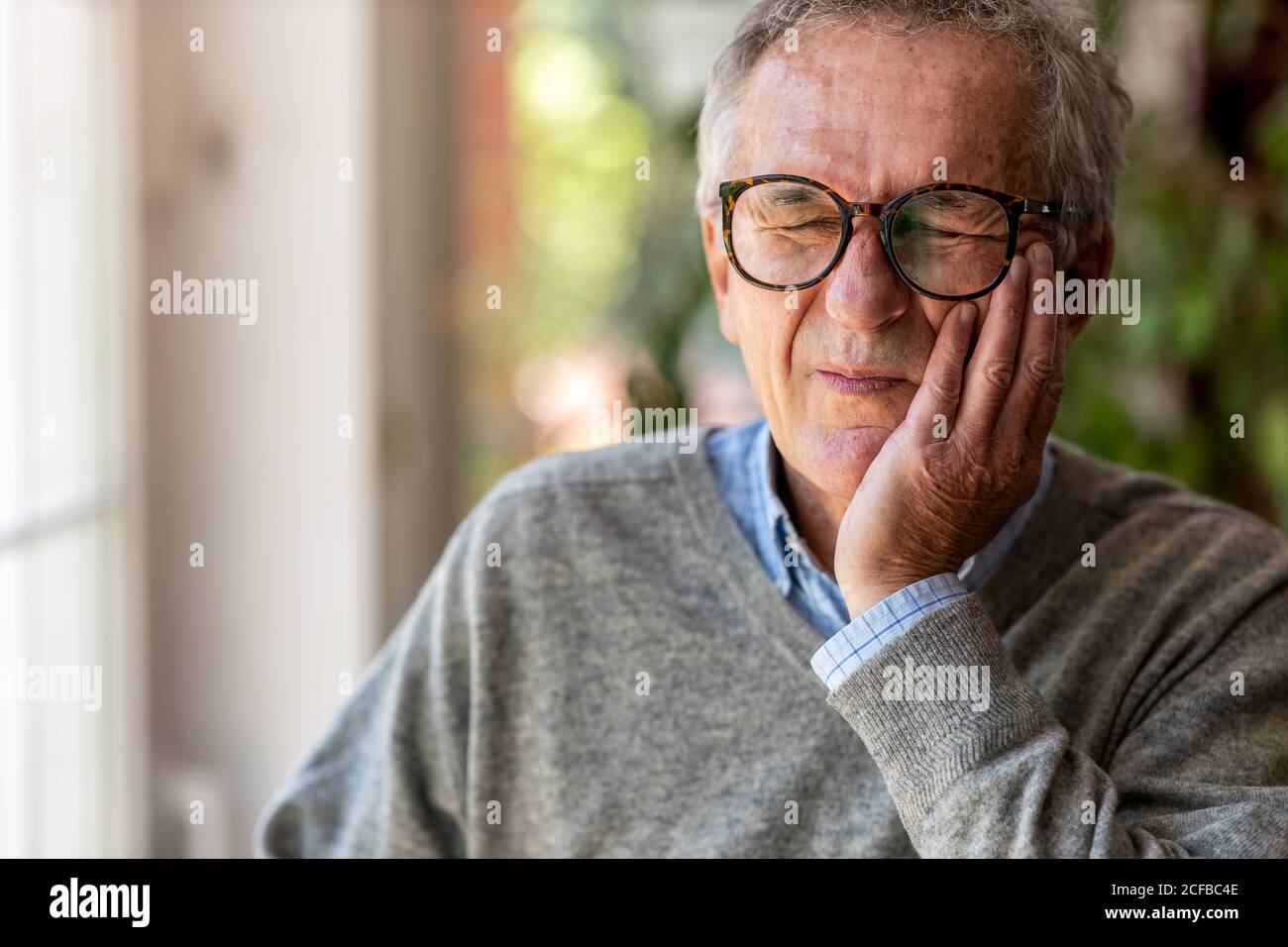 Uomo anziano che avverte un mal di denti Foto Stock