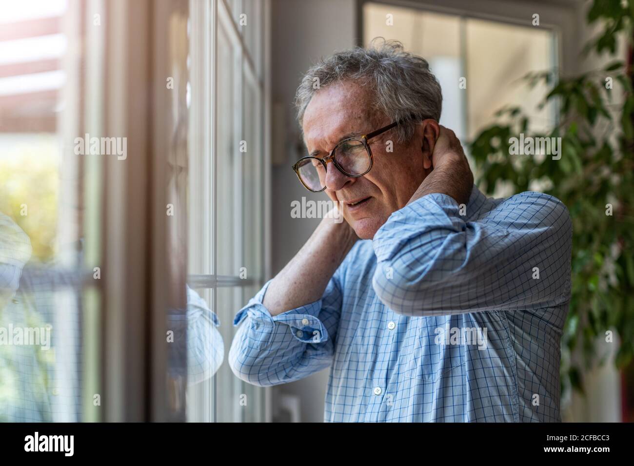 L'uomo anziano che soffrono di dolore al collo Foto Stock