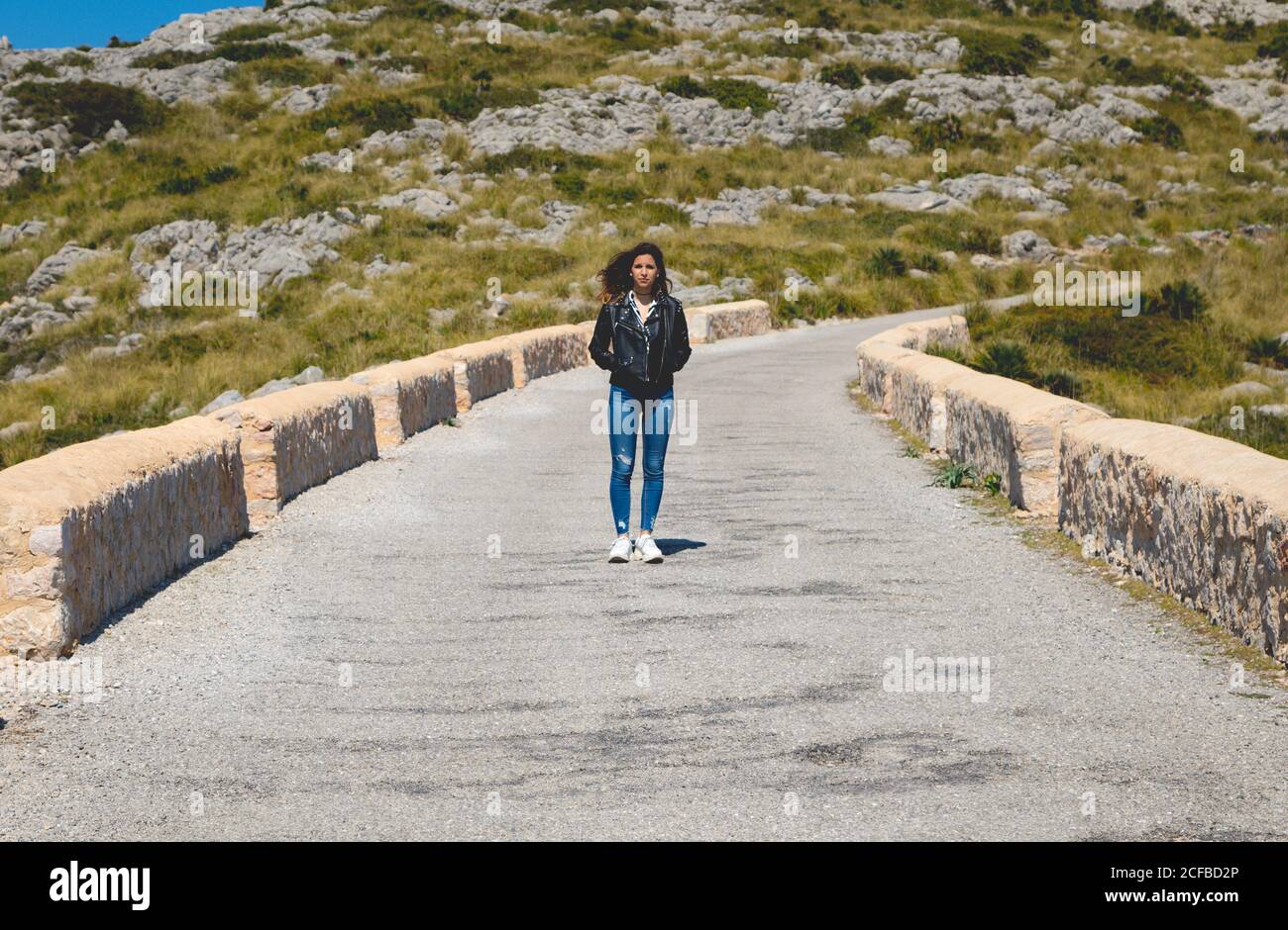Donna in piedi su un sentiero in pietra in campagna Foto Stock