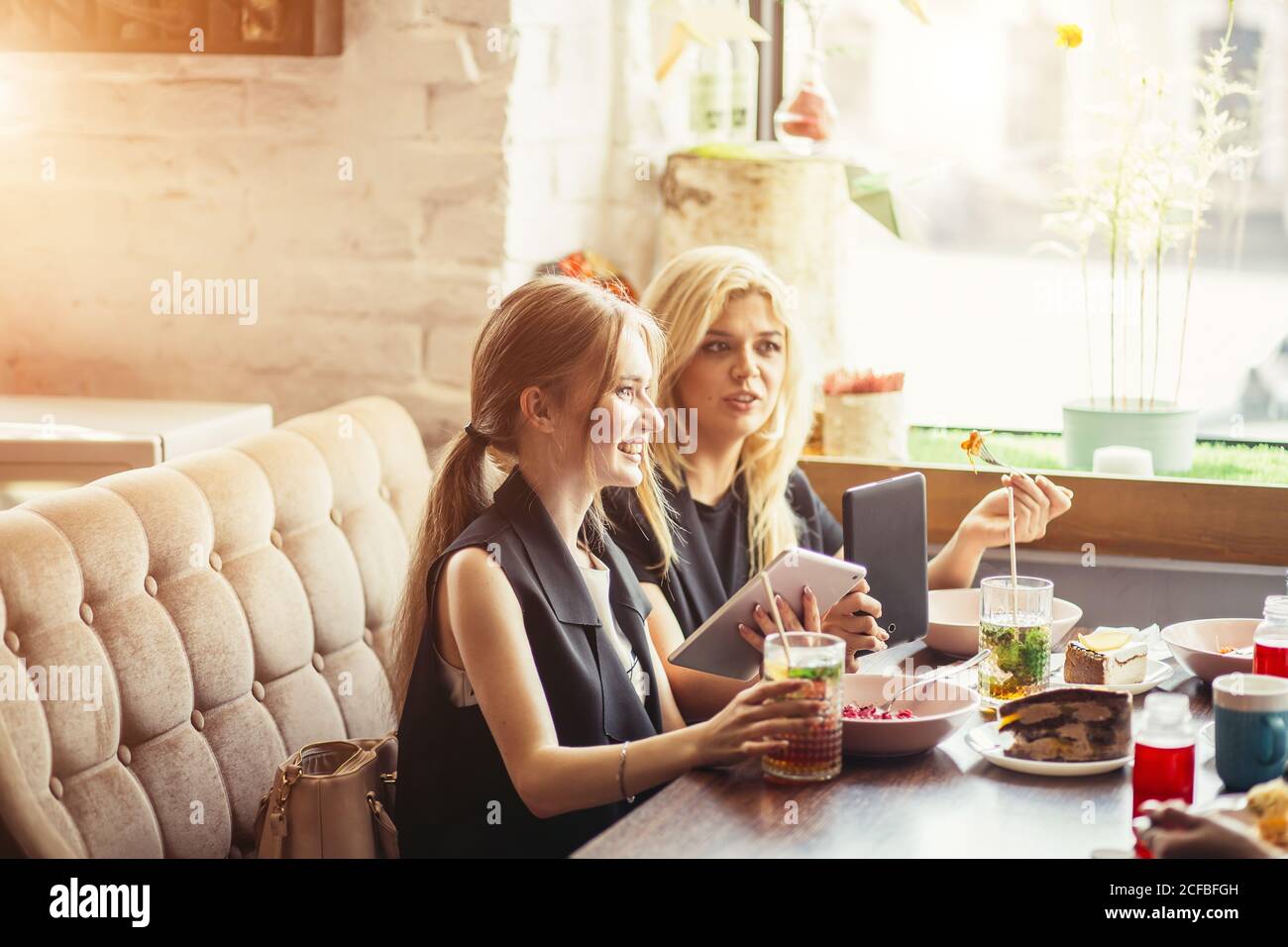 Gli uomini d'affari mangiano, parlano e sorridono mentre pranzano in un caffè Foto Stock