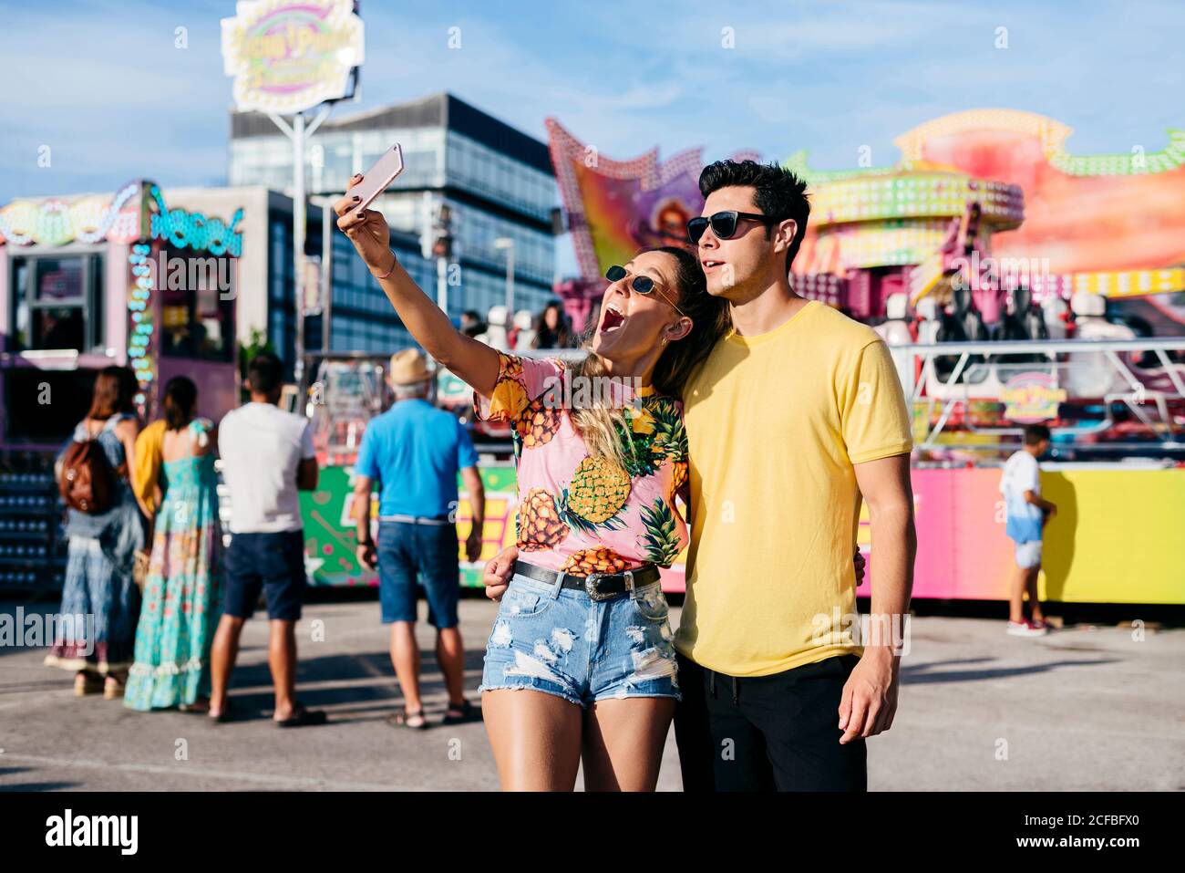 Donna gioiosa prendendo selfie con il ragazzo in fiera Foto Stock