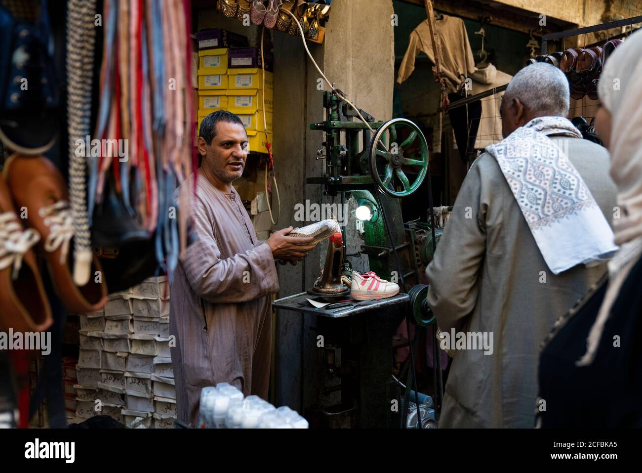 Uomo egiziano che vende scarpe in un mercato all'aperto Foto Stock