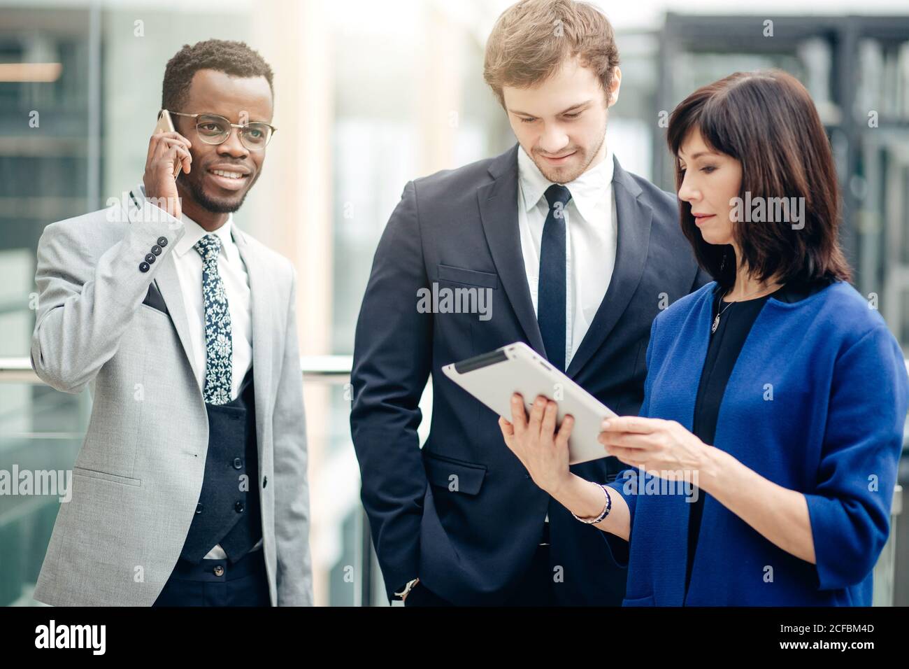 Team di colleghi multietnica lavorando insieme su atablet. Foto Stock