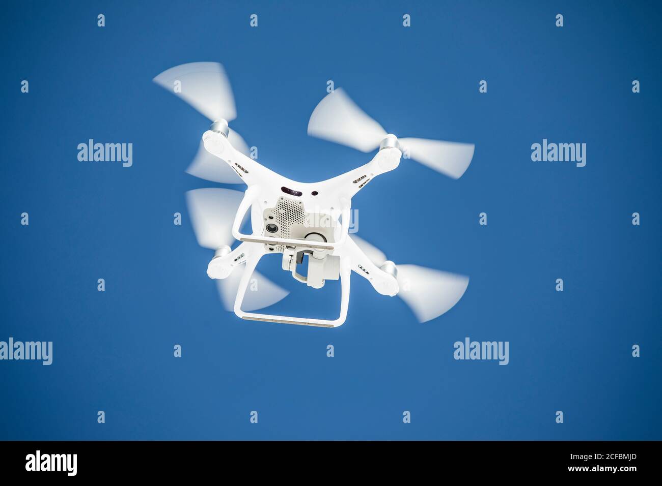 Vista ad angolo basso del drone che vola durante una giornata di cielo blu. Foto Stock