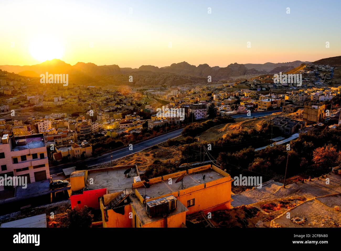 Tramonto con vista sulla città di Wadi Musa, con Petra in lontananza Foto Stock