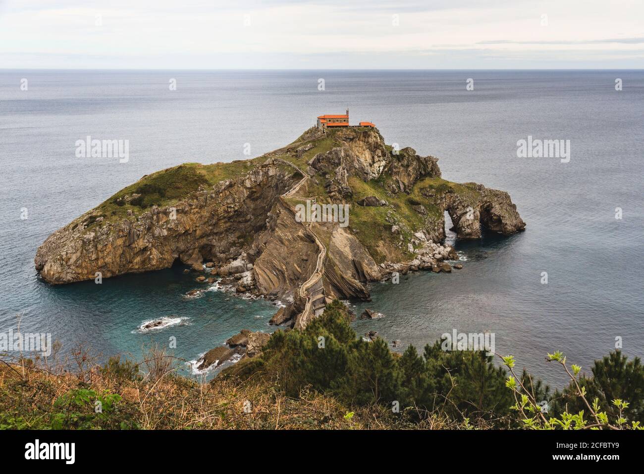 San Juan de Gaztelugatxe a Bermeo (Pais Vasco, Spagna). E' un'isola molto famosa grazie alla serie 'Game of Thrones'. Sull'isola c'è una lei Foto Stock