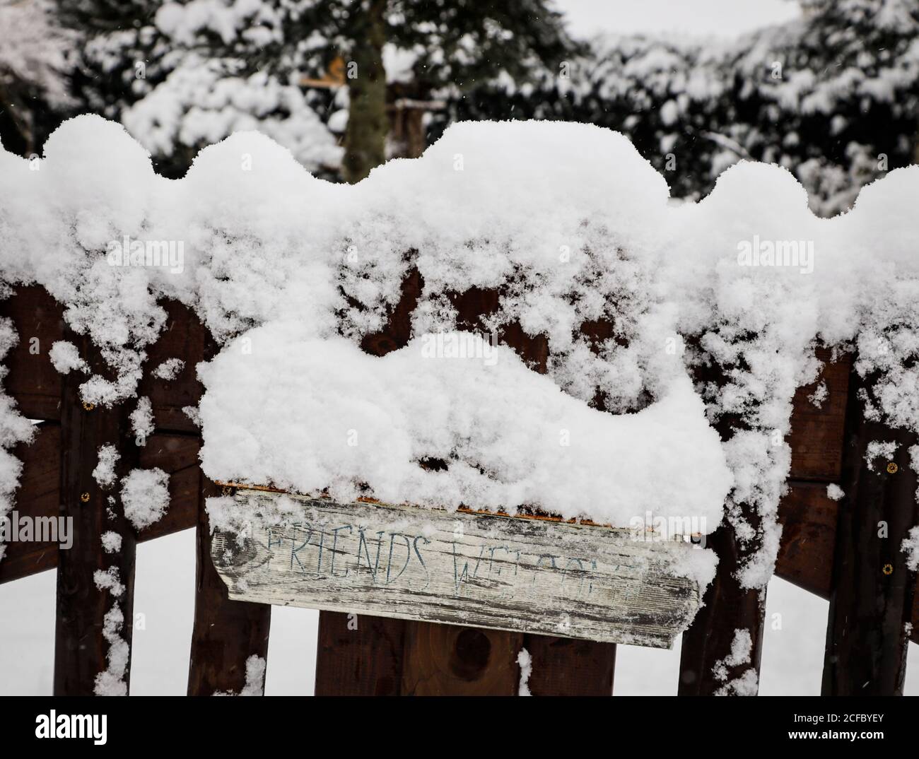 cartello in legno bianco con gli amici vi accolgono in inverno Foto Stock