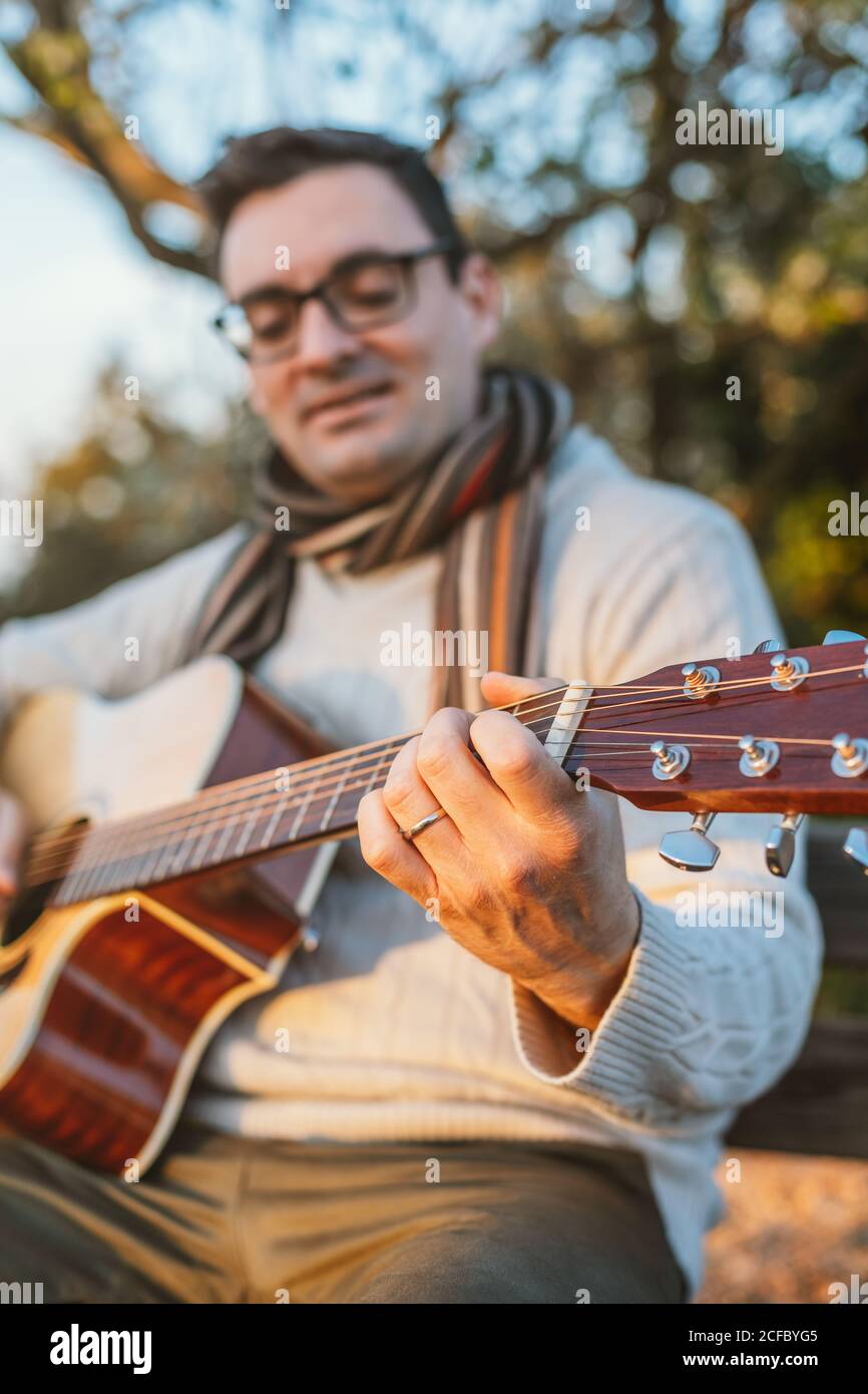 uomo che suona la chitarra all'esterno Foto Stock