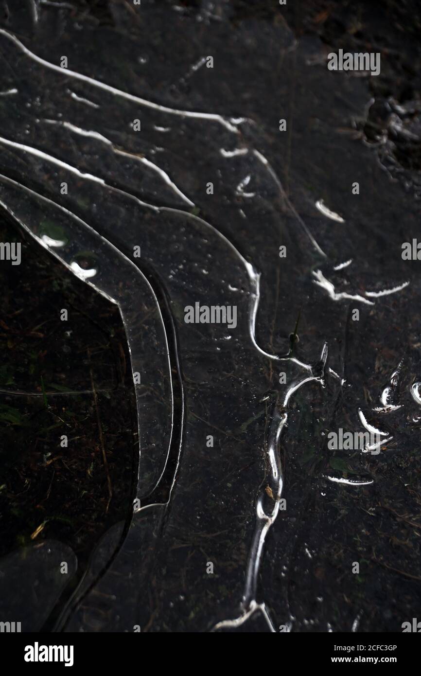 Dall'alto, chiocera di acqua scura congelata con ghiaccio sottile rivestimento Foto Stock