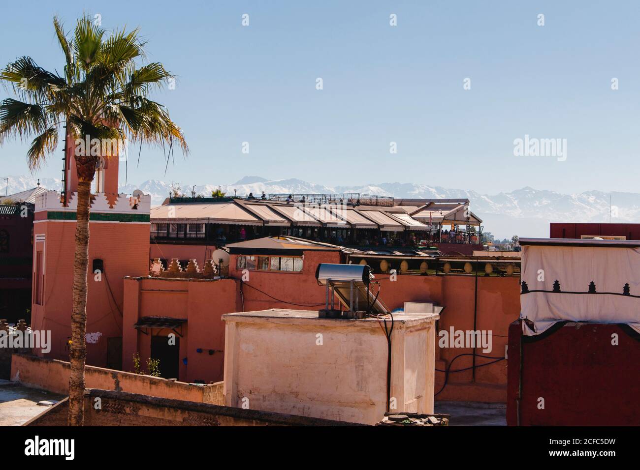 Sopra i tetti della medina a Marrakech con un Vista sulle montagne dell'Atlante Foto Stock