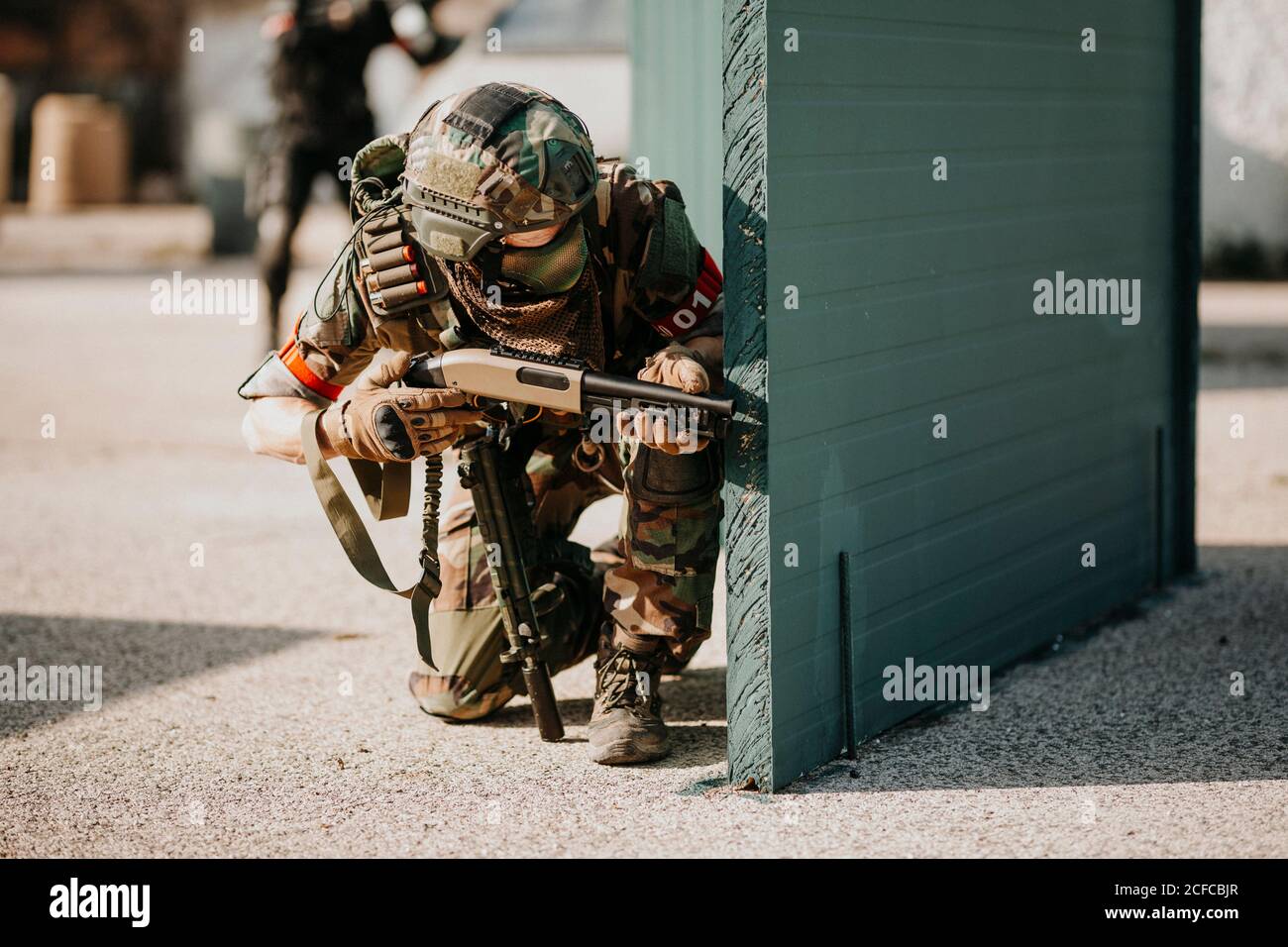 airsoft player inginocchiato con fucile Foto Stock