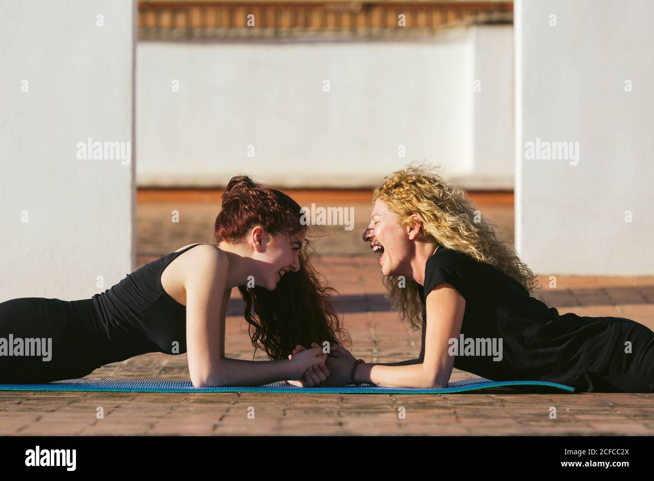 Le donne sottili che fanno la posizione della tavola durante la pratica di yoga Foto Stock