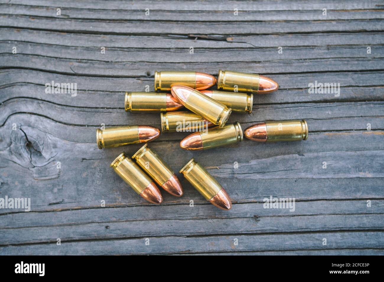 Vista di diversi proiettili disposti su un tavolo - luce diurna - pistole concettuali Foto Stock