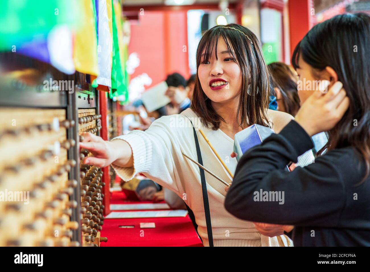 Le giovani donne che hanno ottenuto la loro fortuna a senso-ji in Asakusa, Giappone Foto Stock