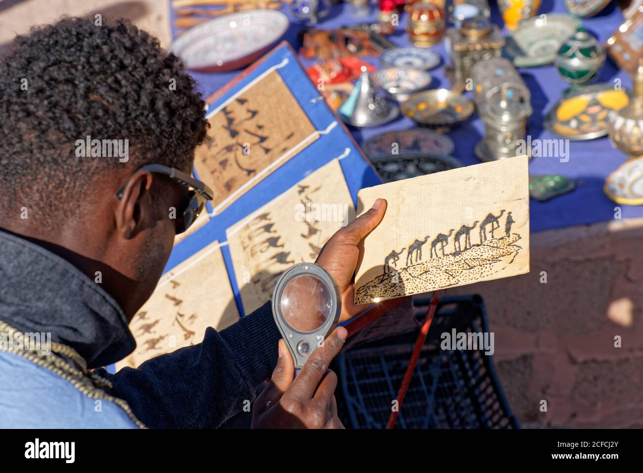 AIT Benhaddou, vendor artista, creativo, Marocco, energia solare, energia, commercio, giovane uomo, lente d'ingrandimento Foto Stock