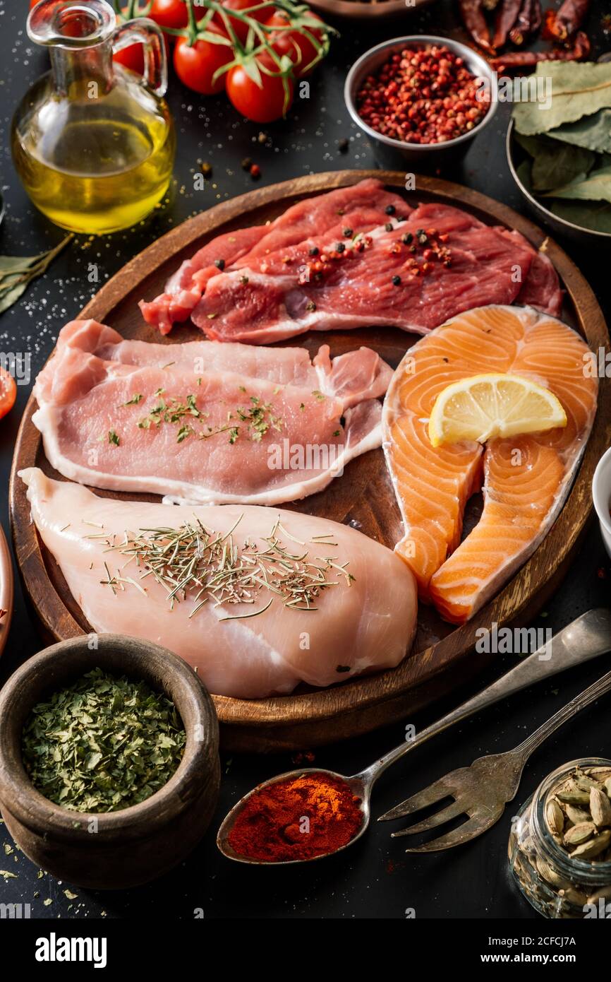 Piatto di proteine circondato da spezie e condimenti tabella Foto Stock