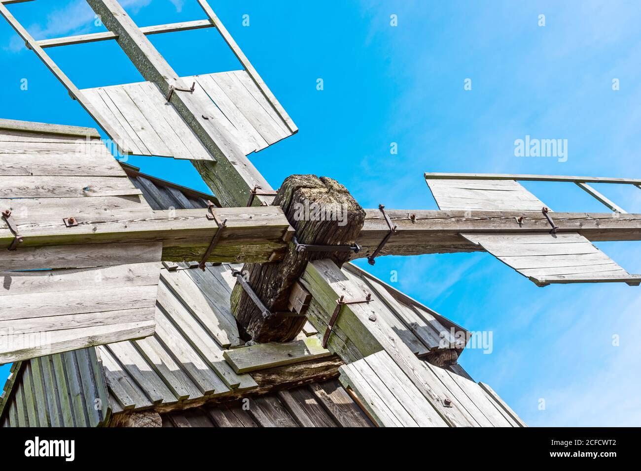 Dettaglio della testa rotante di un postmulino contro un cielo blu Foto Stock