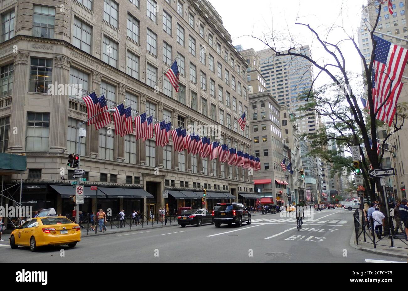 Edificio Saks Fifth Avenue fiancheggiato da bandiere americane, New York City, Stati Uniti Foto Stock