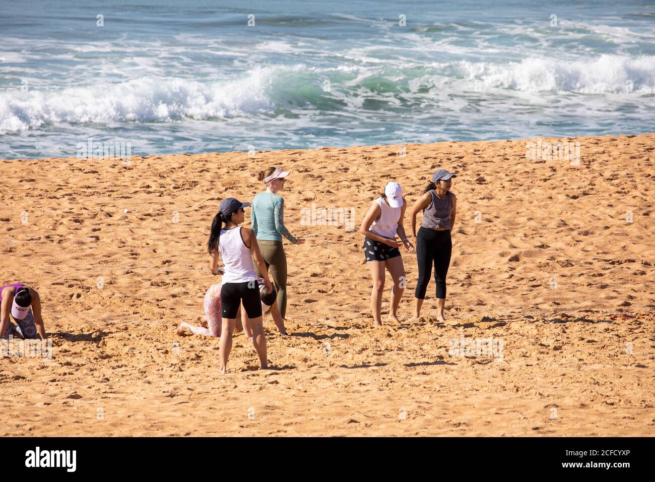 Le donne si allenano e rimangono in forma con un personal trainer Narrabeen spiaggia a Sydney, Australia Foto Stock