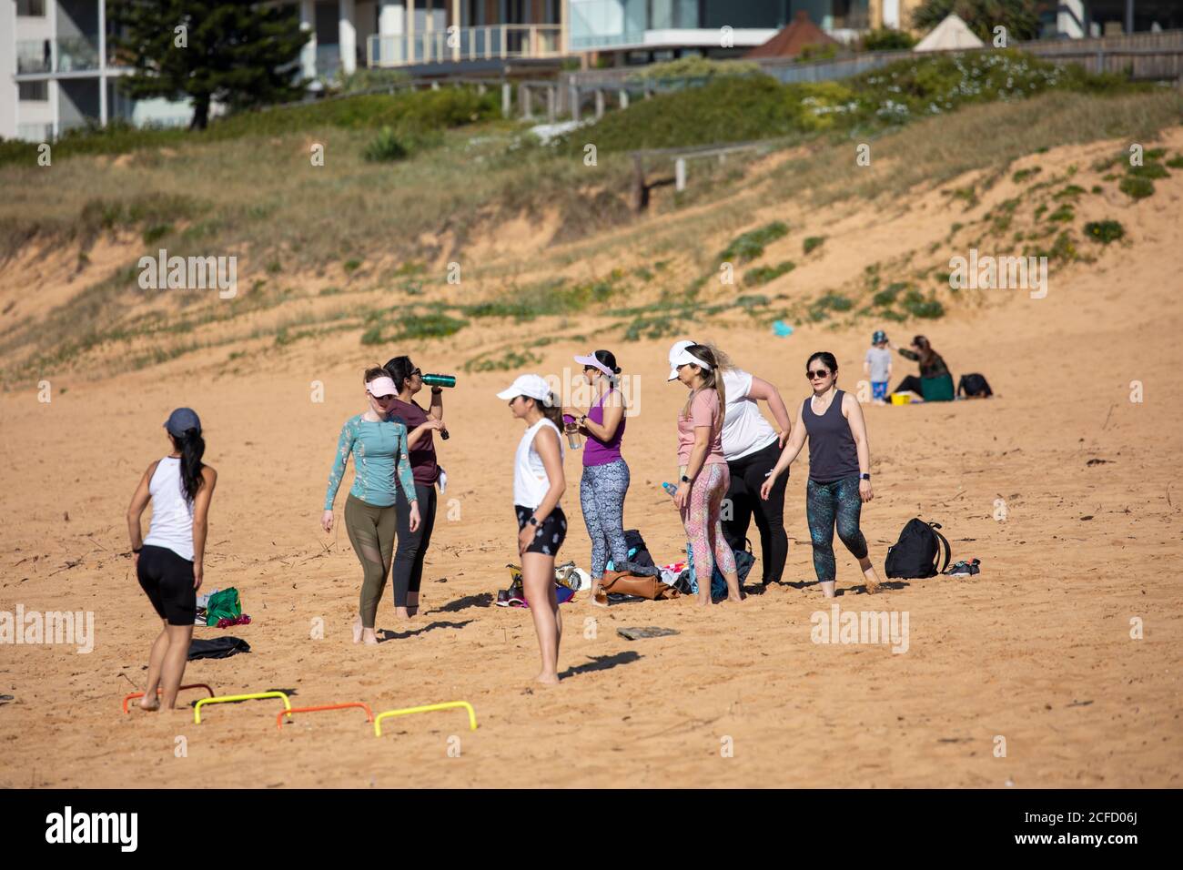 Le donne australiane di stile di vita che fanno le esercitazioni di mattina presto sulla spiaggia di Narrabeen A Sydney, Australia Foto Stock