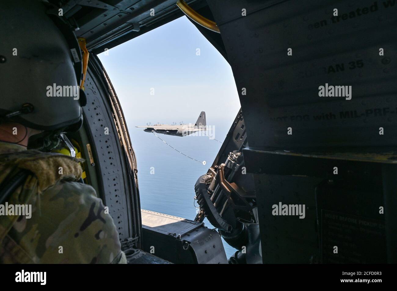 Un 301st Rescue Squadron Special Mission Aviator guarda un HC-130J Combat King II aeromobili prepararsi a rifornire HH-60G Pave Hawk elicotteri sopra l'Oceano Atlantico 3 settembre 2020. Gli aeromobili sono assegnati alla 920esima ala di salvataggio situata sulla base dell'aeronautica di Patrick, la Fla. Il salvataggio dell'aeronautica è l'unica entità del DoD specificamente organizzata, addestrata ed equipaggiata per condurre le operazioni di recupero del personale nelle zone ostili o negate come missione primaria. (STATI UNITI Air Force foto di Tech. SGT. Kelly Goonan) Foto Stock