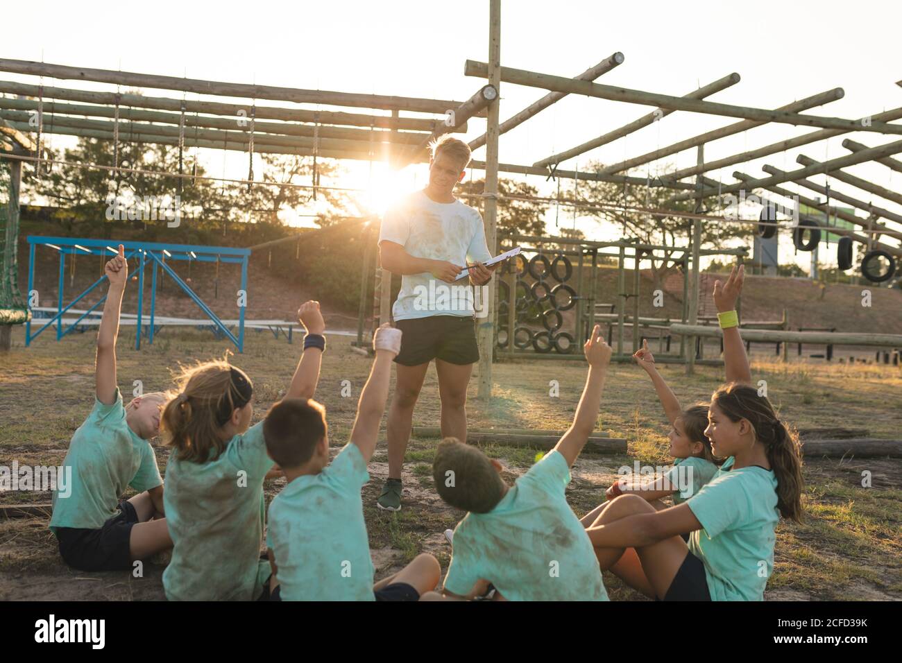 Allenatore di fitness maschile che dà istruzioni ai bambini a un bootcamp Foto Stock