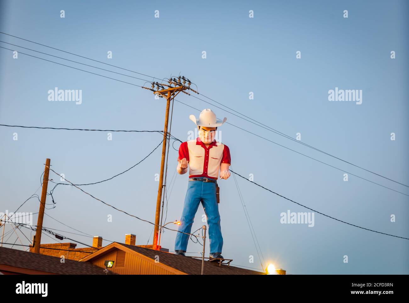 Lexington New Mexico USA - Settembre 2015; uomo Bib in grande cappello texano fatto di fibergass sul tetto dell'edificio. Foto Stock