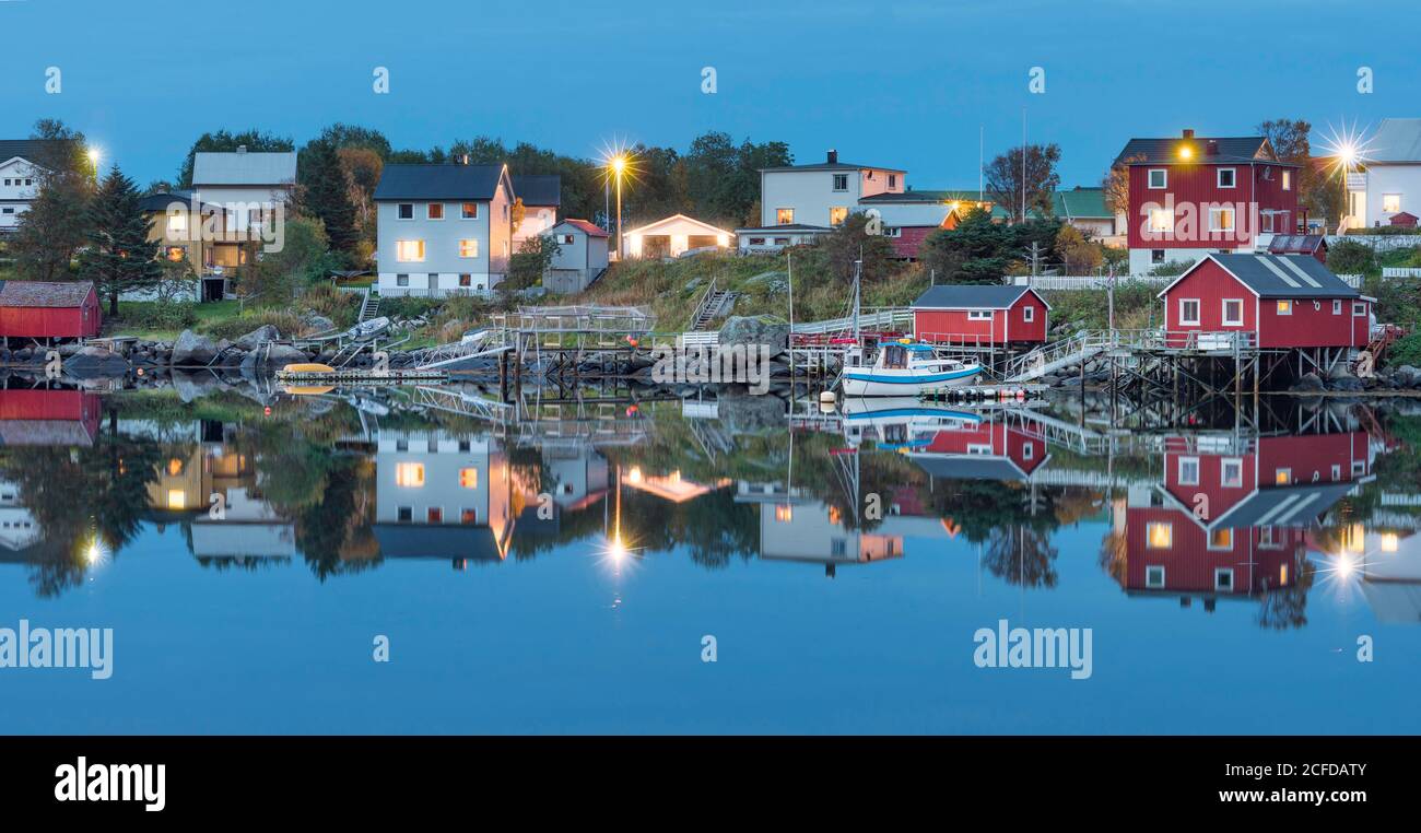 Le case di legno nel villaggio di Reine si riflettono nel crepuscolo nel fiordo, Reine, Lofoten, Nordland, Norvegia Foto Stock Le case di legno nel villaggio di Reine si riflettono nel crepuscolo nel fiordo, Reine, Lofoten, Nordland, Norvegia Foto Stock
