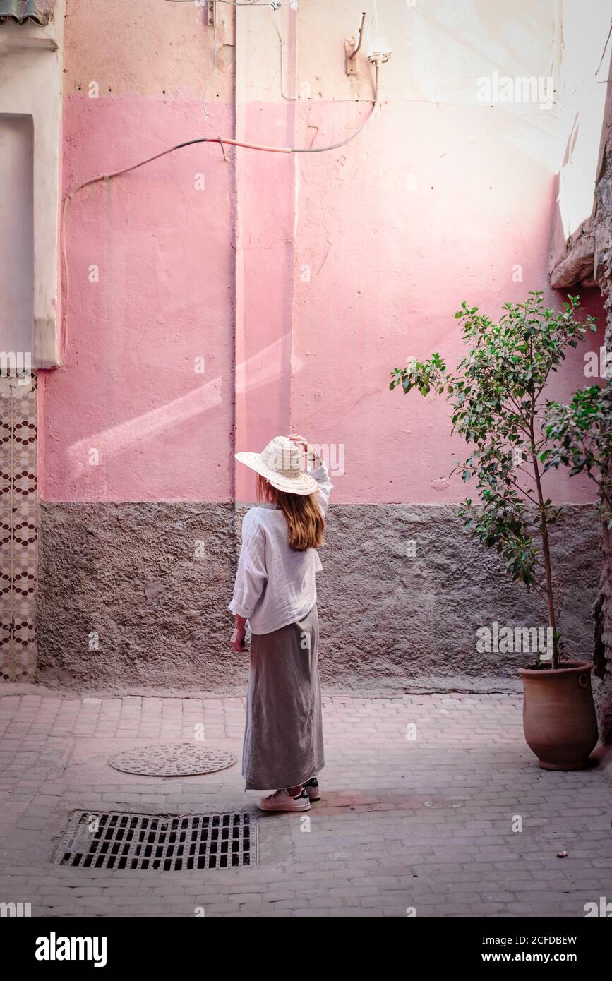 Marrakech, Marocco - Ottobre, 23, 2018: Vista laterale di una donna senza volto turista in cappello elegante camicia e gonna a piedi al vicolo a dondolo Foto Stock