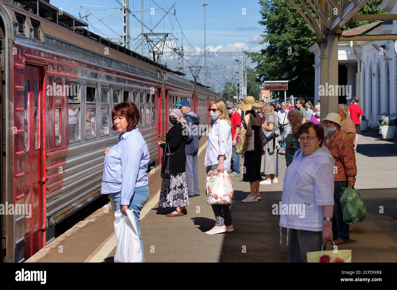 San Pietroburgo, Russia - 08 agosto 2020: La gente si trova sulla piattaforma al momento del covid-19 di fronte al treno elettrico, alcuni di loro in medic Foto Stock
