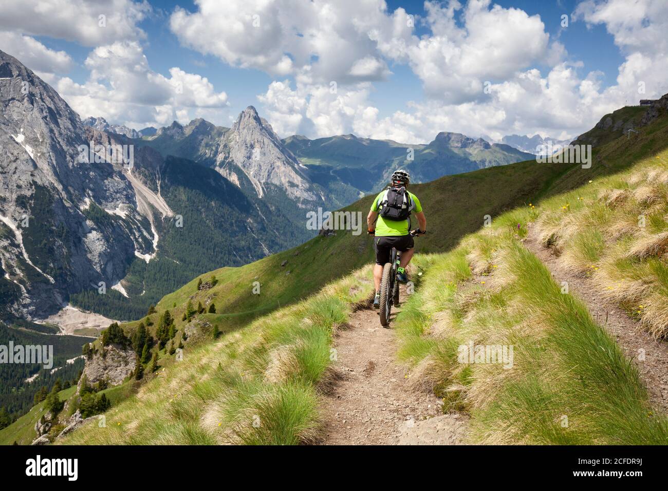 Ciclista con una mountain bike elettrica (e-bike) lungo il sentiero Viel del Pan (Bindelweg) di fronte alla Marmolada, Padon cresta ai confini Foto Stock