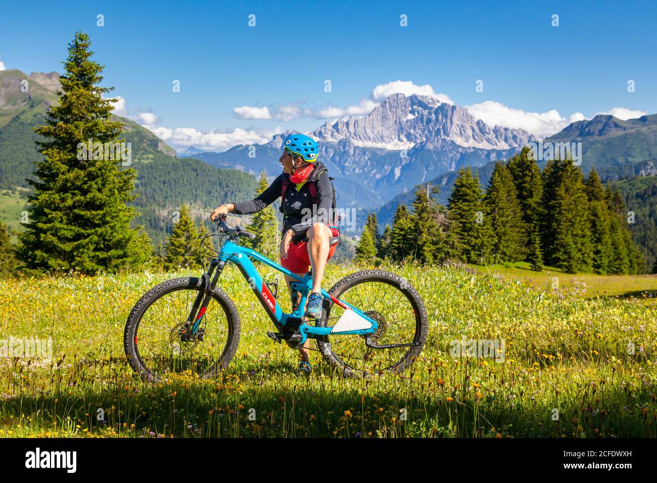 donna con e-bike nel paesaggio naturale del monte cherz, dolomiti, livinallongo del col di lana, belluno, veneto, italia Foto Stock