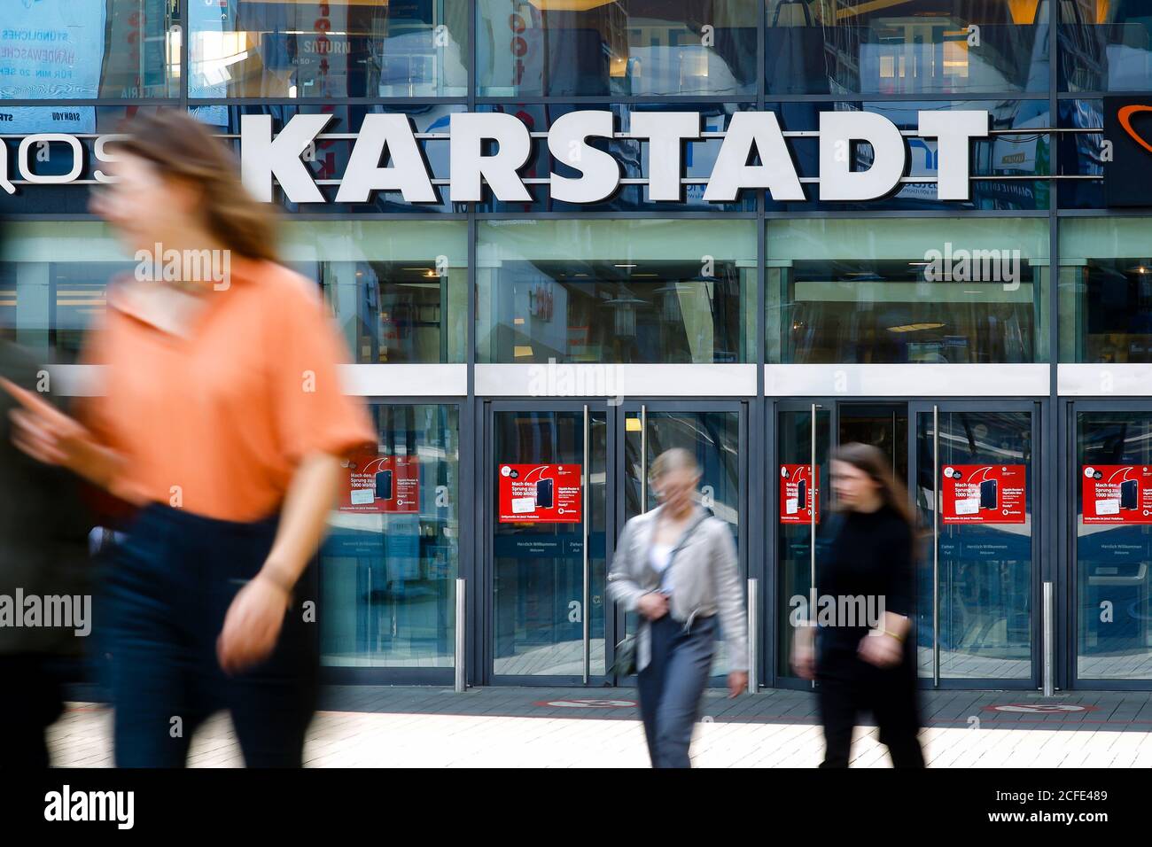 Passer-by di fronte all'entrata del negozio Galeria Karstadt Kaufhof nel centro commerciale Limbecker Platz, zona Ruhr, Essen, Nord Foto Stock