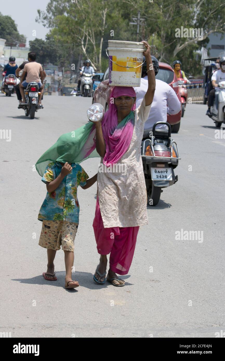 Madre con il suo bambino ragazza che indossa la maschera mantenendo la distanza sociale, di fronte fotocamera. Foto Stock
