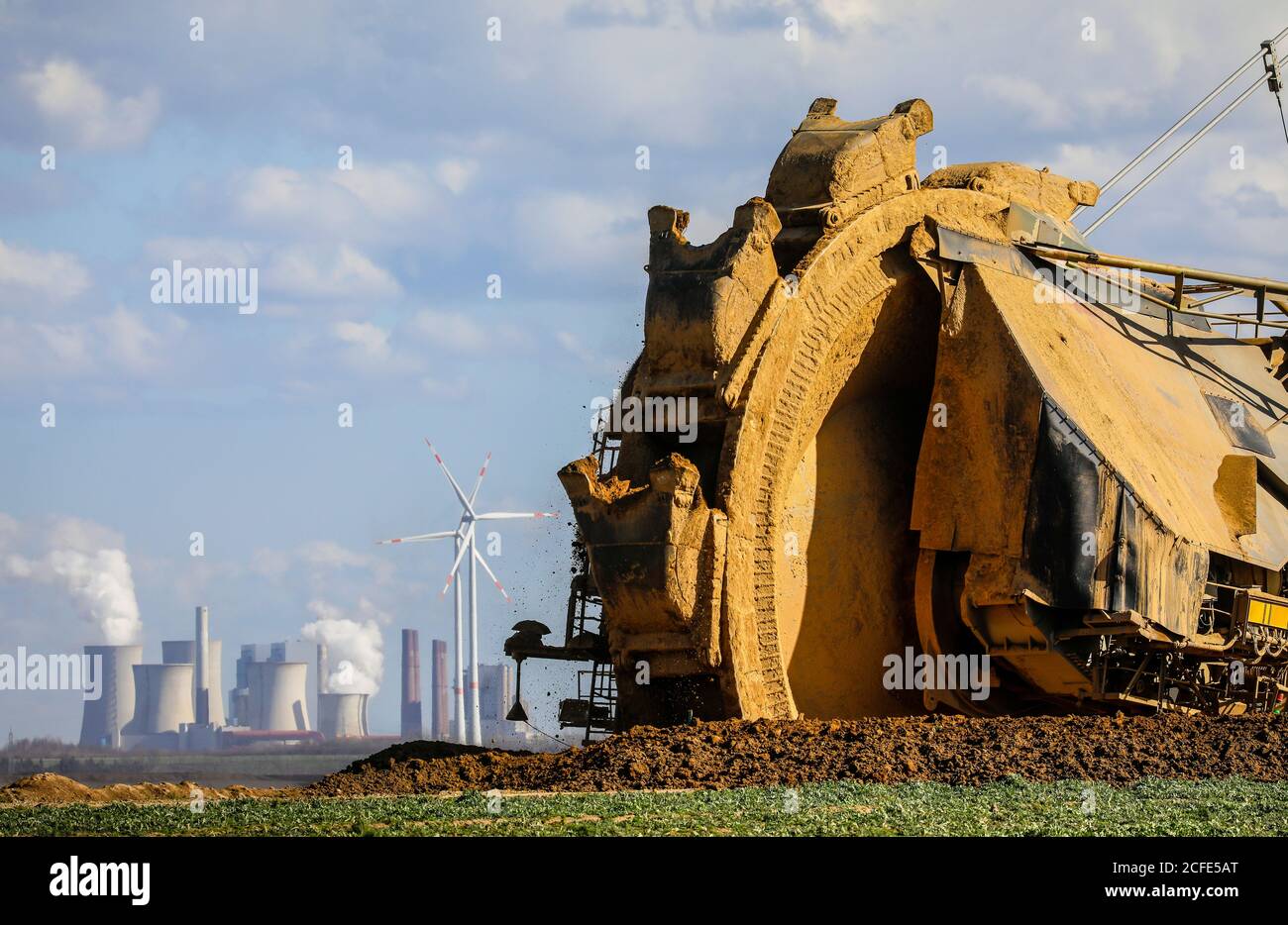 Escavatore a benna-ruota nella miniera di lignite RWE Garzweiler sogna al bordo della demolizione vicino a Keyenberg, un parco eolico nella parte posteriore e il Foto Stock