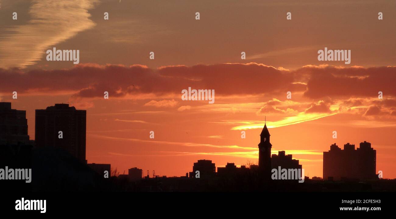 Spettacolari silhouette scure degli edifici al tramonto, New York. Spettacolare tramonto rosso. Nuvole arancioni. Cieli brucianti. Cielo panoramico celeste. Cielo colorato. Foto Stock