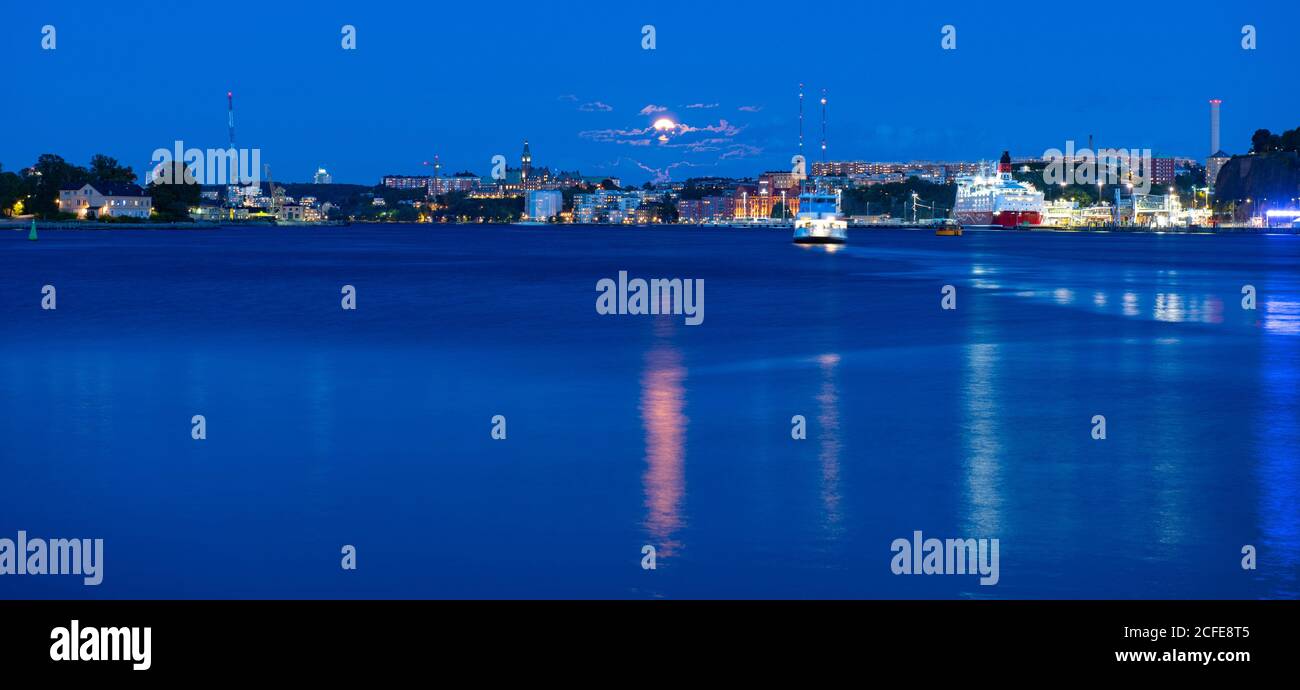 Splendida vista sul mare di Stoccolma al crepuscolo e traghetto che galleggia sul Mar Baltico, Svezia. Cielo chiaro di luna. Foto Stock
