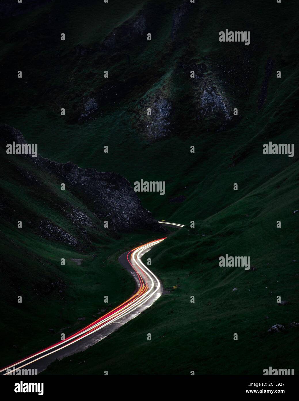 I sentieri leggeri dalle luci dell'auto sul passo di Winnats nel Peak District, Derbyshire, Regno Unito Foto Stock