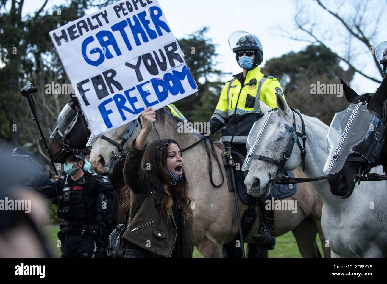 Melbourne, Australia 5 settembre 2020, una donna protestore tiene il suo placard aloft mentre si alza il terreno di fronte a cavalli di polizia al Freedom Day Anti-maschera e anti-blocco protesta al Santuario della memoria a Melbourne Australia. Credit: Michael Currie/Alamy Live News Foto Stock