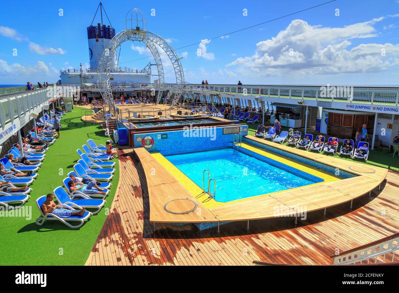 I passeggeri si godano il sole sulla terrazza della piscina di una nave da crociera. Fotografato a bordo del P&o Liner 'Pacific Jewel', 3/22/2018 Foto Stock