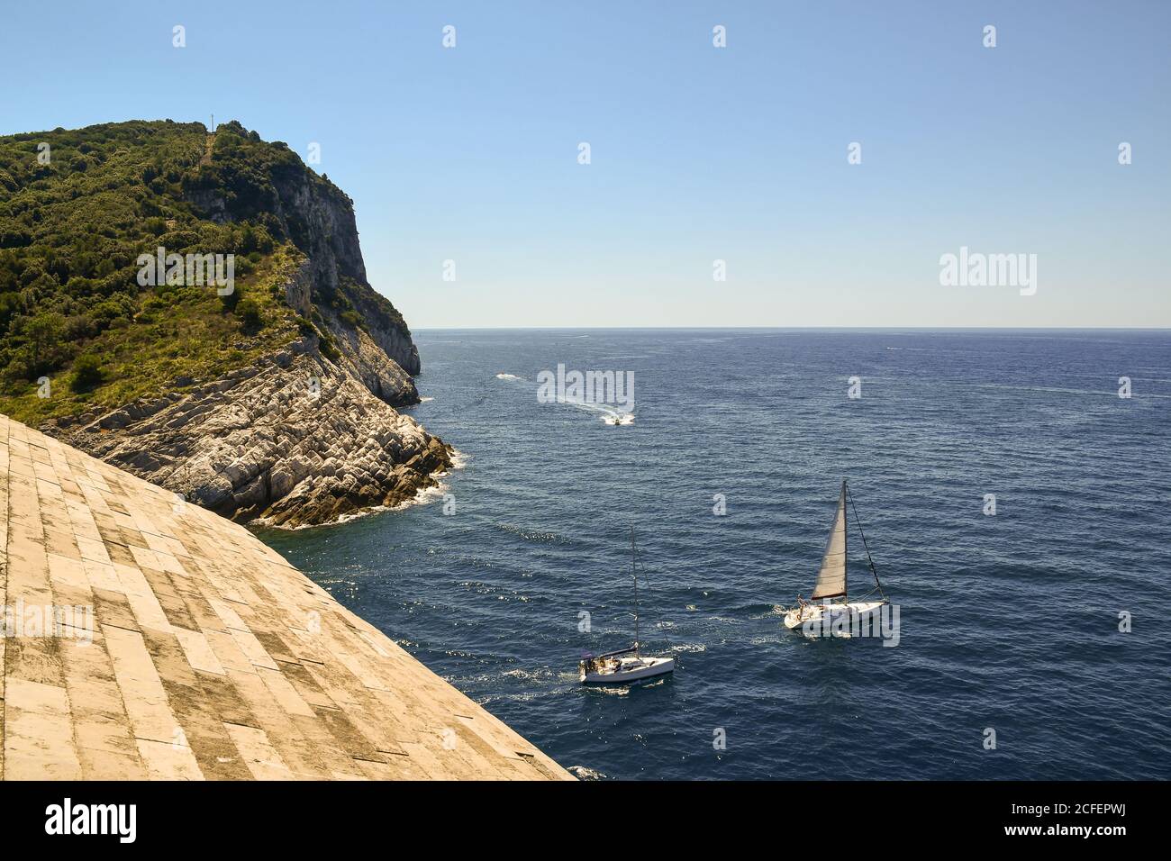 Vista panoramica dal tetto della Chiesa di San Pietro con barche a vela e l'Isola Palmaria, Porto Venere, la Spezia, Liguria, Italia Foto Stock