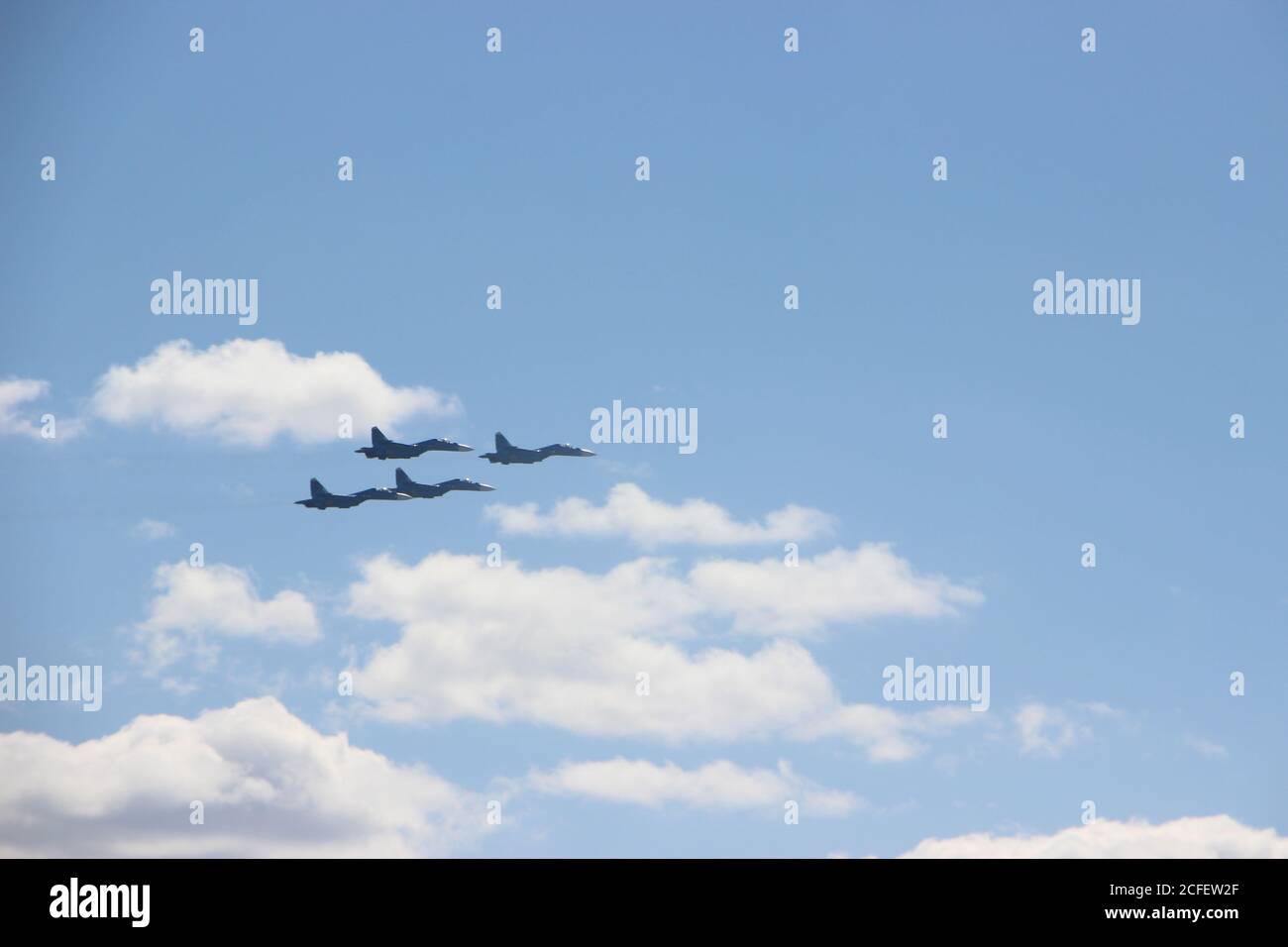 Quattro combattenti Spitfire militari silhouette in cielo blu con nuvole bianche. Concetto militare Foto Stock