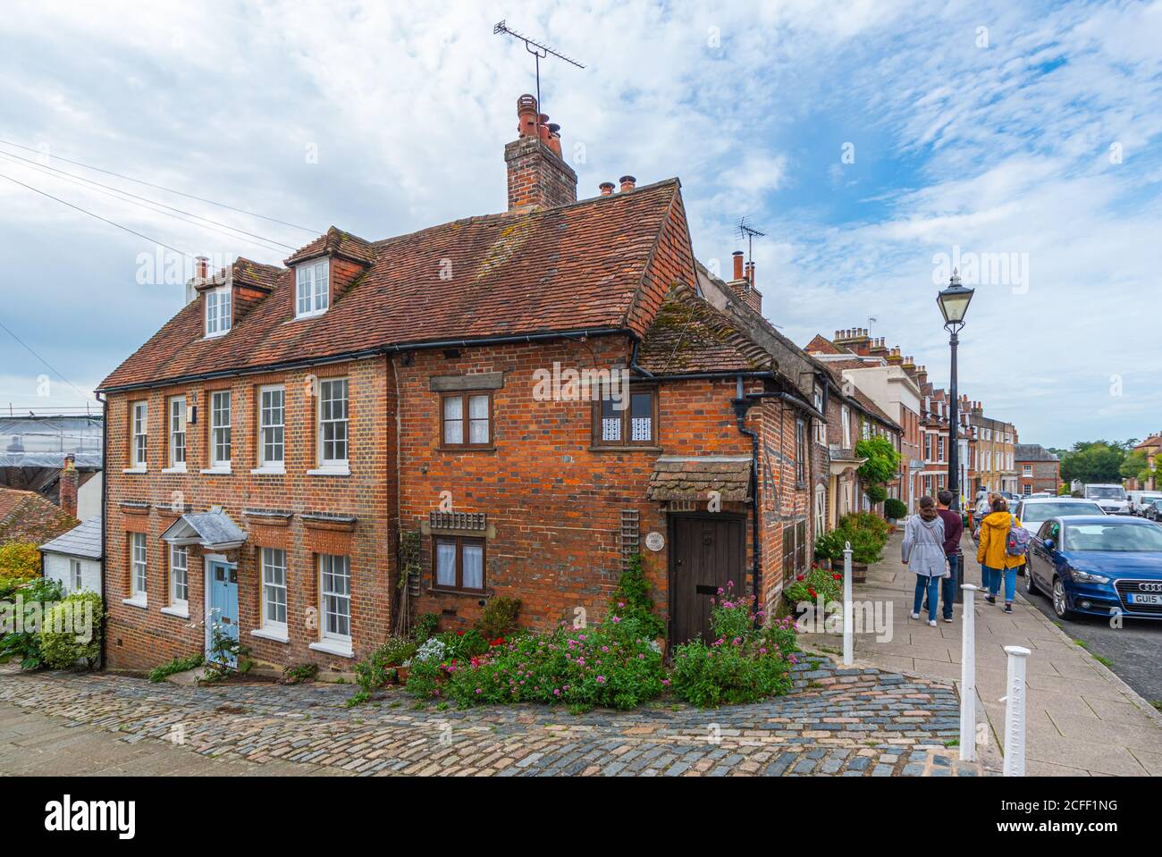 Persone che camminano oltre la casa georgiana e un vecchio cottage di Bakers Arms Hill su Maltravers Street, Arundel, West Sussex, Inghilterra, Regno Unito. Foto Stock